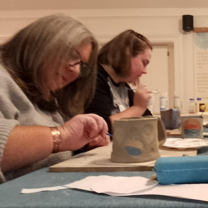 Painting Pottery Close up of a child's hand while painting a ceramic imprint of their own hand