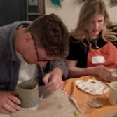 Painting Pottery Close up of a child's hand while painting a ceramic imprint of their own hand